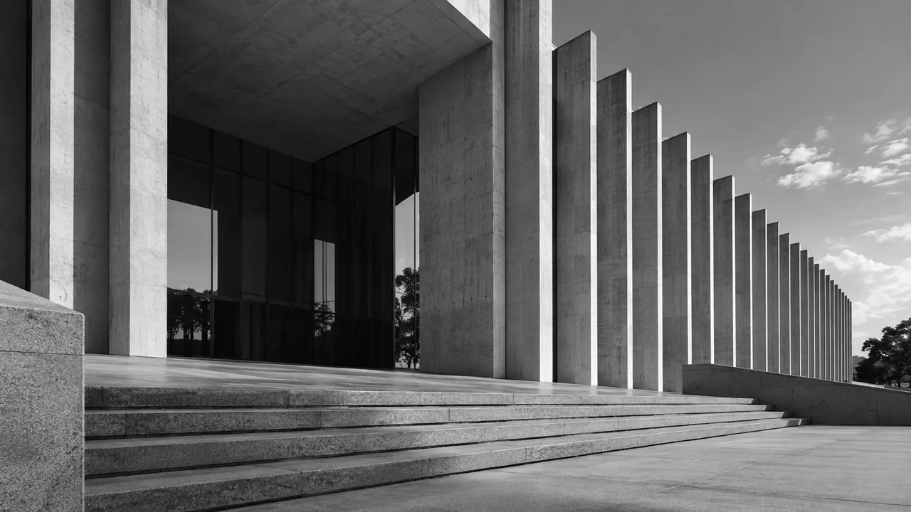 Fachada de edifício institucional com colunas de concreto e escadaria